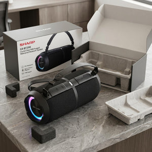 Sharp GX-BT390 speaker unboxing with protective eco-friendly packaging on a stone countertop.