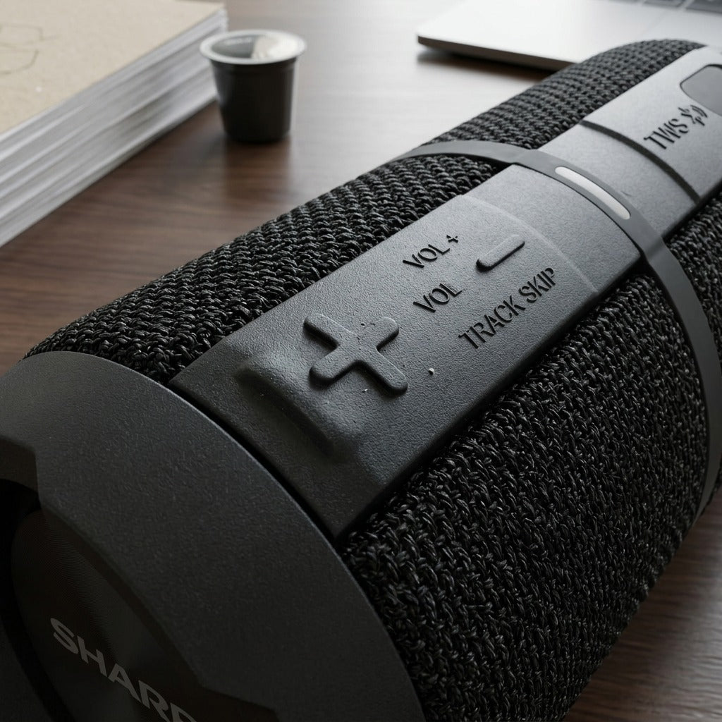 Macro detail of the Sharp GX-BT390 rugged speaker showing tactile volume controls and mesh texture.